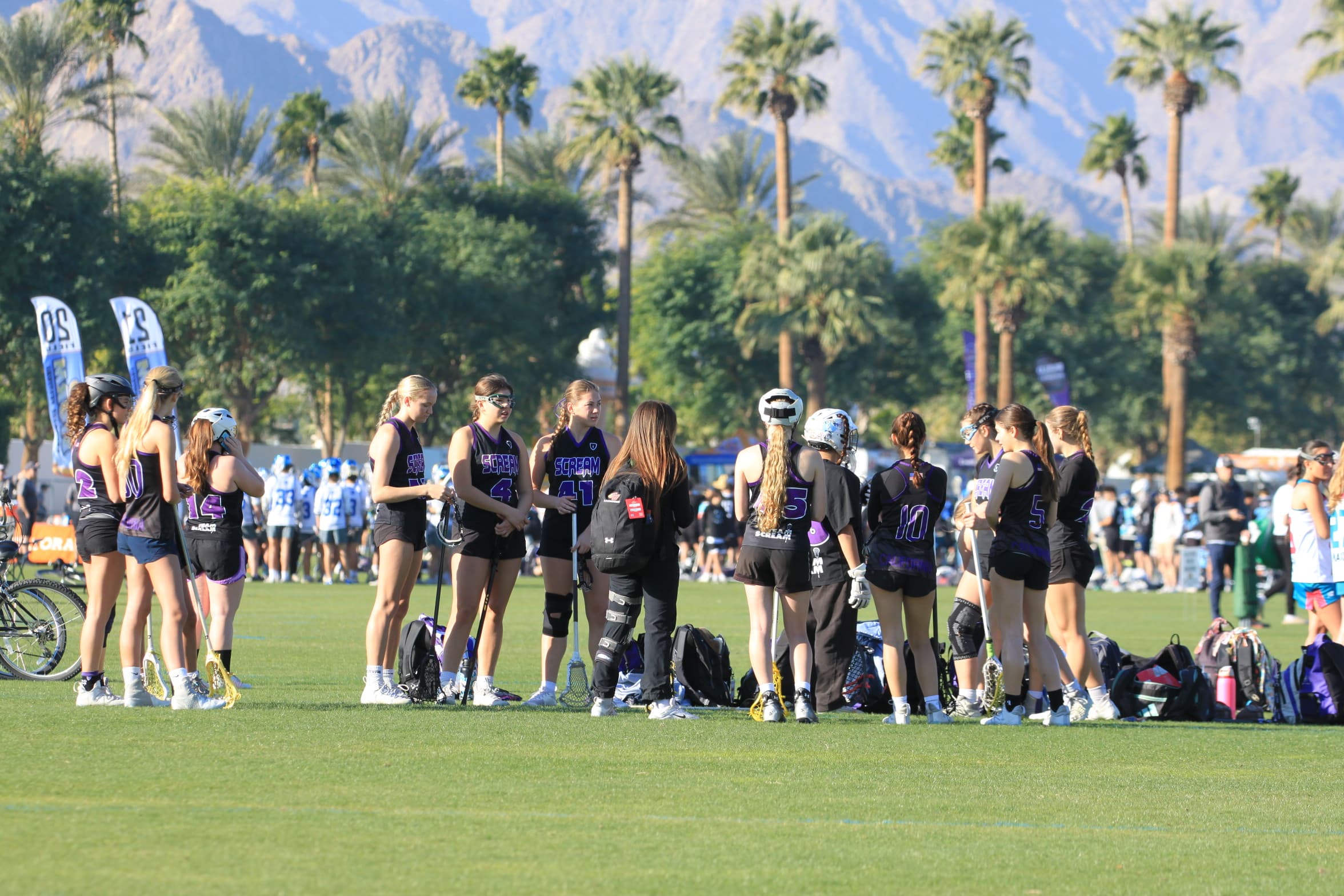 Scream Lacrosse team huddle with palm tree backdrop
